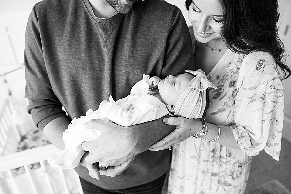 mom and dad smiling down at newborn baby girl spartanburg newborn photographer