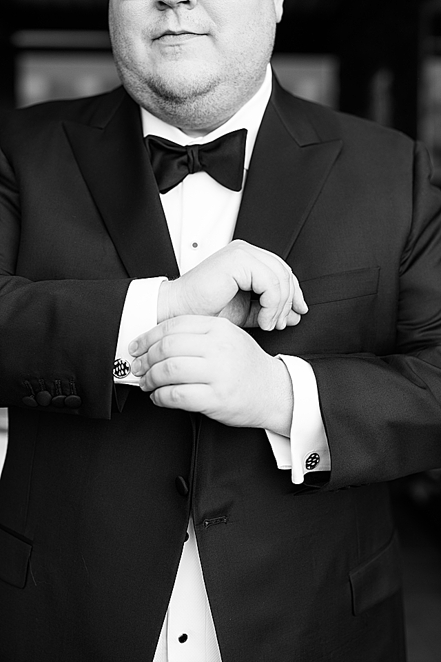 groom touching cufflinks
