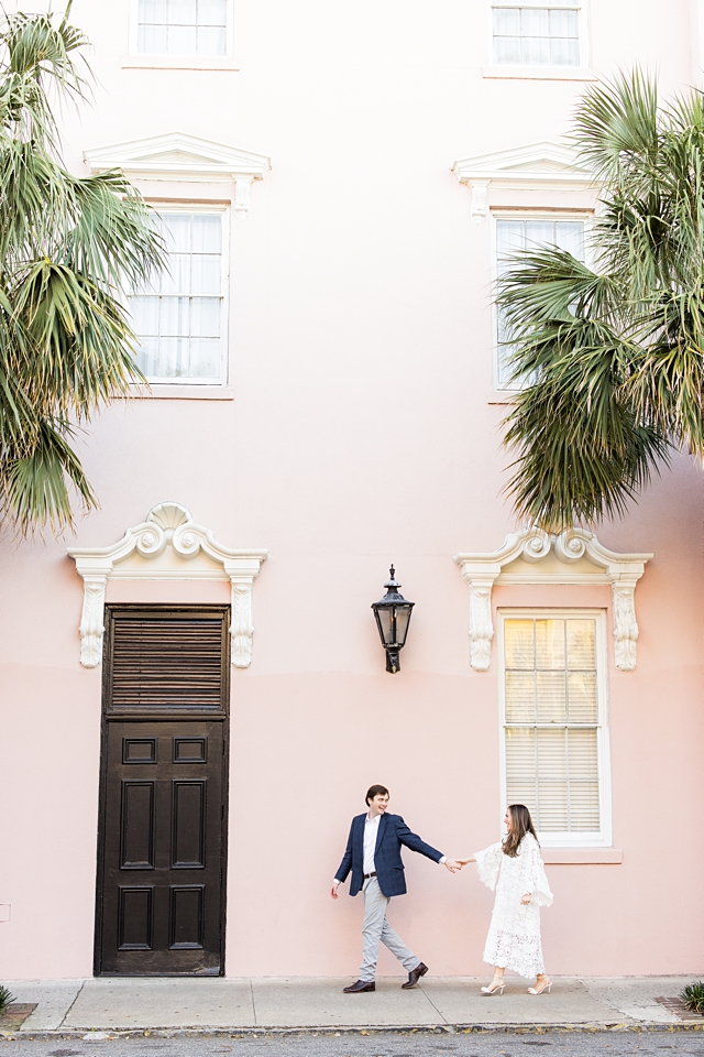 downtown charleston engagement session couple in front of pink hotel